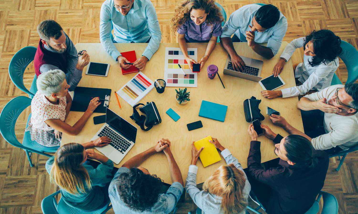 A group of diverse professionals gathered around a board table. 